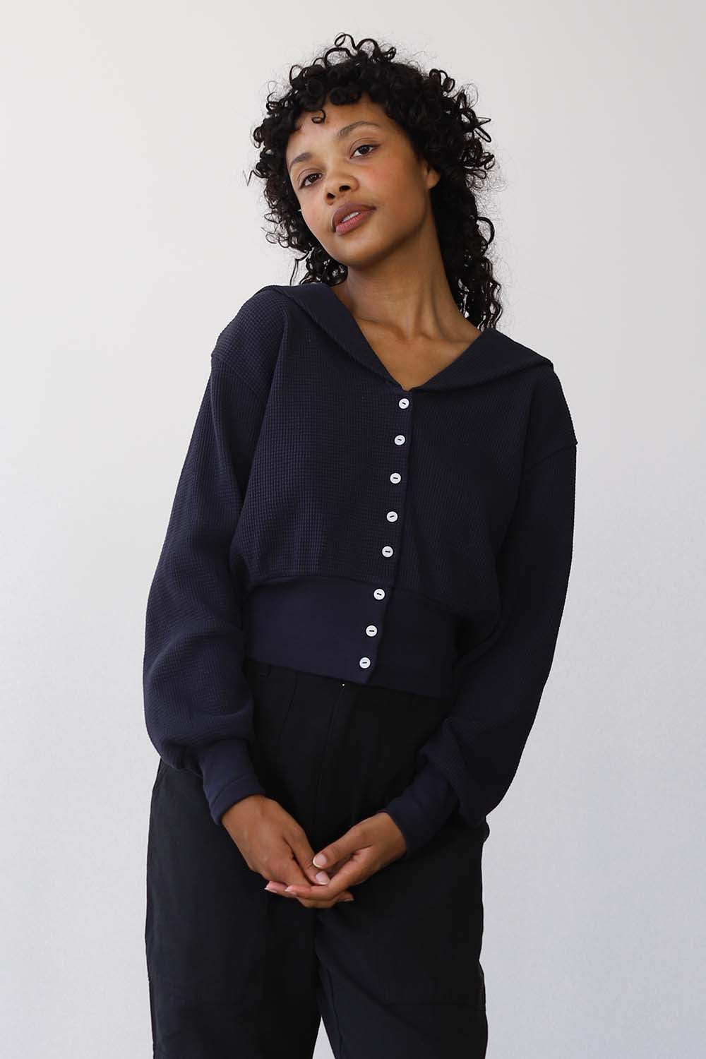 Woman wearing a black cardigan against a white background