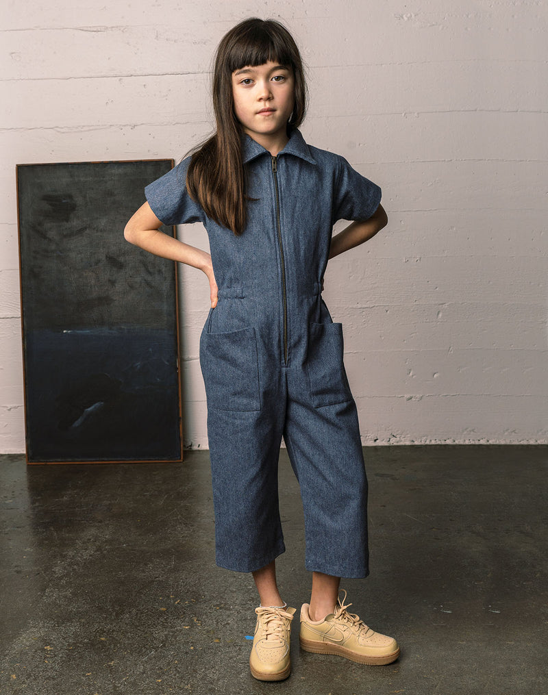 Girl wearing a denim utility suit made with upcycled denim materials