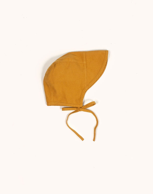 Noble Brimmed Bonnet in Turmeric color tied in a bow